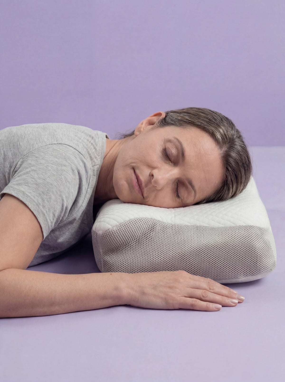 Mujer durmiendo boca abajo sobre la almohada ergonómica
