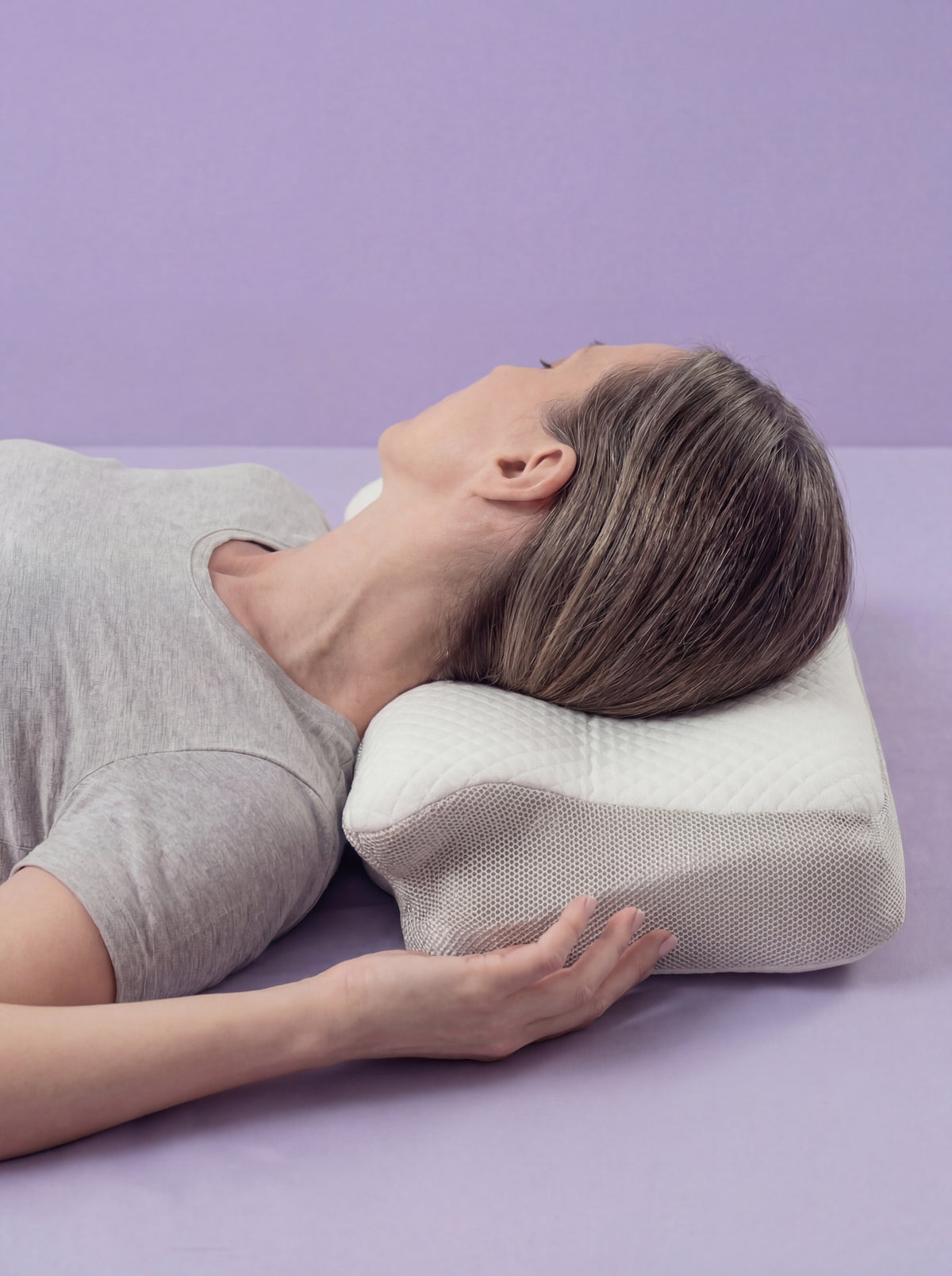 Mujer cambiando de postura mientras duerme sobre la almohada